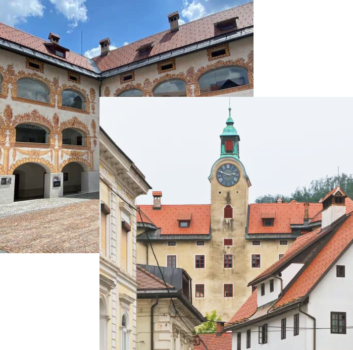 Grad Gewerkenegg v Idriji z notranjim arkadnim dvoriščem z bogatimi poslikavami ter pogledom na grajski stolp z uro, obdan z okoliškimi hišami z rdečimi strehami.